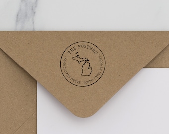 May include: A round return address stamp with the text "THE FOSTERS", "6958 CLOVER DRIVE", "SOUTH LYON, MI 48178" and an outline of the state of Michigan.