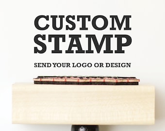 May include: A custom stamp with the words "CUSTOM STAMP" in bold black letters. Below the text is the phrase "SEND YOUR LOGO OR DESIGN". The stamp has a wooden handle and a black base.