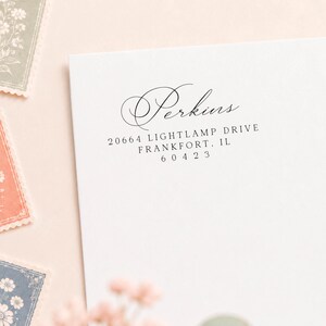 May include: A white envelope featuring black printed text that reads Perkins, 20664 Lightlamp Drive, Frankfort, IL 60423. The name Perkins is written in a decorative script font, while the address is in a clean, simple serif typeface.