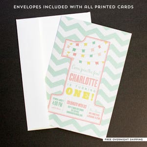 May include: A birthday invitation with a mint green chevron pattern and a large number one. The invitation includes the text "Come join the fun! Charlotte is turning ONE!" and event details. A white envelope is included.