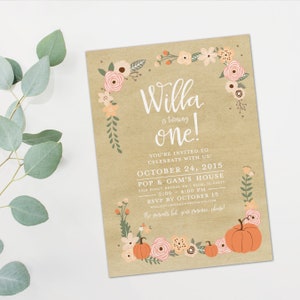 May include: A kraft paper birthday invitation with floral and pumpkin accents. The invitation reads "Willa is turning one!" with event details. The design includes peach, pink, and green floral elements.