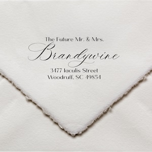 以下が含まれることがあります： 「The Future Mr. & Mrs. Brandywine 3477 Jaculis Street Woodruff, SC 49854」と黒インクでスタンプされた白い封筒