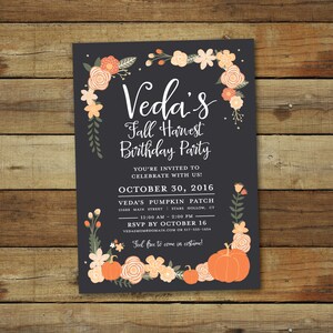 May include: A dark grey invitation card with floral and pumpkin decorations. The text reads "Veda's Fall Harvest Birthday Party" with event details, including the date, time, and RSVP information. The invitation is decorated with orange and cream-coloured flowers and pumpkins.