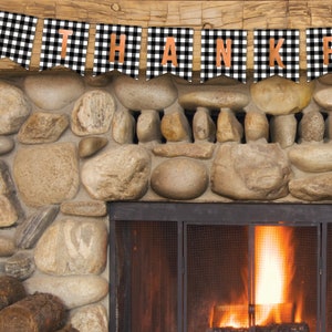 Peut inclure: Une banni&egrave;re &agrave; carreaux noirs et blancs avec le mot "THANK" en lettres orange est suspendue au-dessus d'une chemin&eacute;e en pierre avec un feu qui br&ucirc;le &agrave; l'int&eacute;rieur.