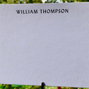 May include: A blank white card with the name "WILLIAM THOMPSON" printed in black at the top.