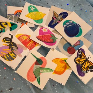 May include: A collection of 10 small, colorful illustrations on white cardstock. The illustrations include a hummingbird, a butterfly, a bee, a lemon, a strawberry, a cherry, a blueberry, an orange, a peach, and a moth.