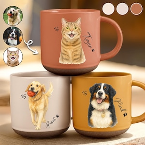 Puede incluir: Tres tazas de cerámica con retratos de mascotas. Una es naranja con una ilustración de gato y el nombre "Tiger". Otra es beige con un golden retriever y el nombre "Groot". La tercera es amarilla con un perro de montaña bernés y el nombre "Pink".