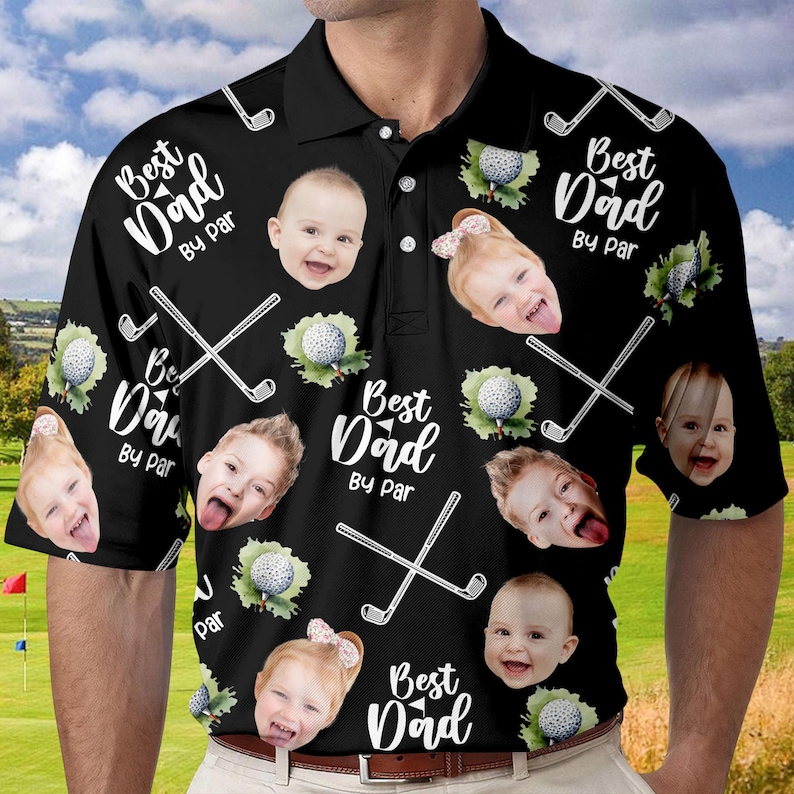 Puede incluir: Camiseta de golf negra con una impresi&oacute;n blanca que dice "Best Dad By Par" y presenta un patr&oacute;n repetido de palos de golf, pelotas de golf y caras de ni&ntilde;os.