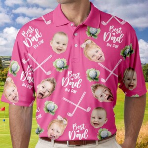 Puede incluir: Camiseta polo rosa de tem&aacute;tica de golf con el texto "Best Dad By Par" repetido en todo el dise&ntilde;o. La camiseta presenta m&uacute;ltiples im&aacute;genes de caras de ni&ntilde;os.