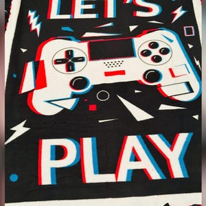 May include: Black blanket with a white and red controller graphic and the words "LET'S PLAY" in a 3D effect. The blanket has a white border and a red and black fringe.
