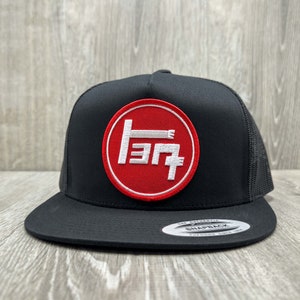 May include: Black trucker hat with a red circle patch featuring a white Toyota logo. The logo is in Japanese characters.
