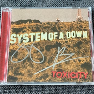 System of A Down – TOXICITY サイン入り：Serj Tankian および Daron Malakian CoA - 保護ケース無料 - 送料無料