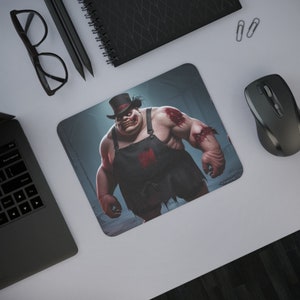May include: A rectangular mousepad featuring a grotesque cartoon character with a top hat and apron. The character has exposed muscle and bloody wounds. The background is a dark, industrial setting. A computer mouse and other office supplies are visible.