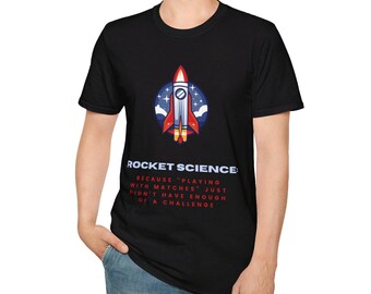 Può includere: Maglietta nera con una grafica di un razzo e il testo "ROCKET SCIENCE: BECAUSE 'PLAYING WITH MATCHES' JUST DIDN'T HAVE ENOUGH OF A CHALLENGE"