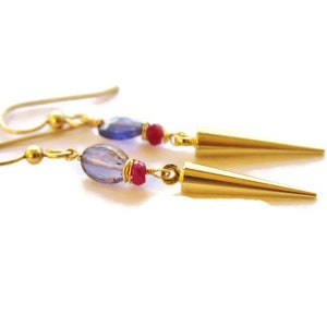 May include: Gold earrings with blue and red gemstone beads and gold spike accents.
