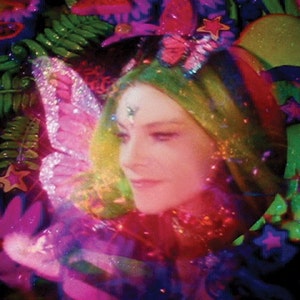 May include: A woman with green hair and a sparkly butterfly headband is surrounded by colorful, glittery decorations. The decorations include stars, butterflies, and leaves. The woman is smiling and looking to the side.