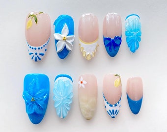May include: Ten different nail designs featuring blue, white, and yellow floral and geometric patterns.