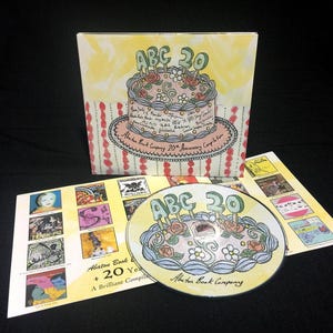 Puede incluir: Compilación en CD con un diseño de pastel que dice "ABC 20" en la portada y el disco. La portada del álbum es amarilla con una ilustración de pastel, y el disco tiene el mismo diseño. Es una compilación del 20 aniversario.