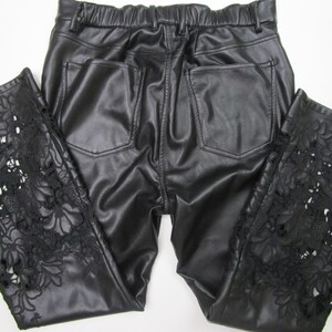 Pu&ograve; includere: Pantaloni in ecopelle nera con elastico in vita e due tasche posteriori. La parte inferiore delle gambe dei pantaloni &egrave; caratterizzata da intricati intagli in pizzo floreale nero che si estendono verticalmente lungo i lati del capo.