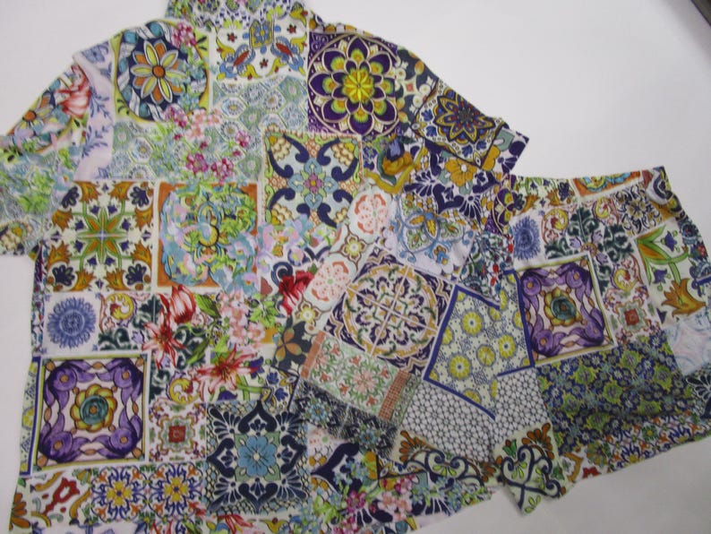 Puede incluir: Un conjunto de camisa de manga corta con botones y pantalones cortos a juego con un estampado de patchwork vibrante y multicolor. La tela muestra una variedad de intrincados patrones florales, geom&eacute;tricos y de azulejos en tonos morado, azul, verde y amarillo.