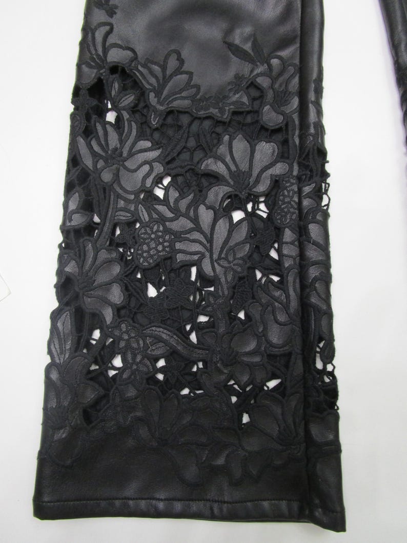 Pu&ograve; includere: Pantaloni neri dal design a gamba larga con intricati motivi floreali tagliati al laser. La parte inferiore del capo presenta dettagliati motivi floreali ritagliati che creano un aspetto simile al pizzo sulla base in tessuto nero.