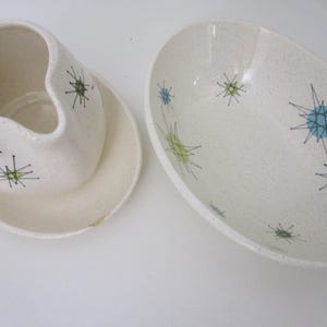 Puede incluir: Un juego de servir de cerámica blanca con un patrón de estrellas azules y verdes. El juego incluye una jarra de crema y un tazón ovalado grande para servir.