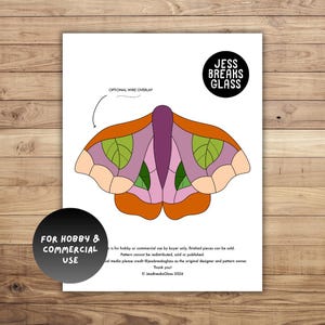May include: A white paper with a colorful moth design, featuring orange, purple, and green segments. The design includes the text "OPTIONAL WIRE OVERLAY" and the logo "JESS BREAKS GLASS". The text "FOR HOBBY & COMMERCIAL USE" is also visible.