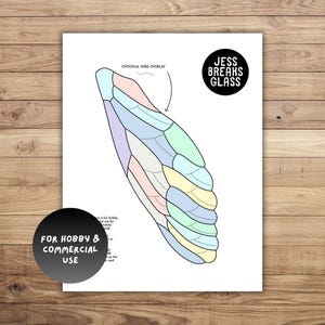 May include: A white print featuring a colorful wing design with the text "OPTIONAL WIRE OVERLAY". The print also includes the text "JESS BREAKS GLASS" and "FOR HOBBY & COMMERCIAL USE".