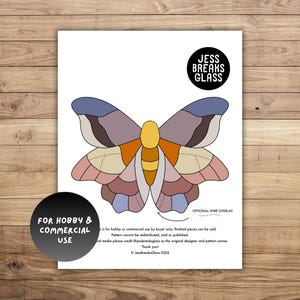 May include: A colorful butterfly pattern on a white paper. The butterfly design features various shades of purple, pink, orange, and yellow. The text "JESS BREAKS GLASS" is in a black circle. The text "FOR HOBBY & COMMERCIAL USE" is in a black circle.