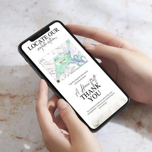 Peut inclure: Un smartphone affiche une carte de New York avec le texte "LOCATE OUR celebration" en haut. L'&eacute;cran affiche &eacute;galement "A Heartfelt THANK YOU" et d'autres textes. Le t&eacute;l&eacute;phone est tenu dans deux mains.