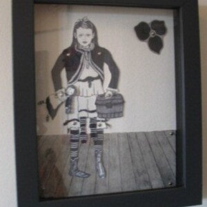 May include: A framed black and white illustration of a girl holding a suitcase and a doll. The girl is wearing a dress, a jacket, and boots. The background is a wooden floor with a black flower in the upper right corner.