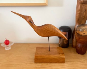 Vintage hand carved wooden bird sculpture on a wooden stand,  vintage Scandinavian style wooden bird on a metal pole and wooden stand