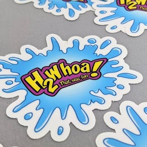 May include: A blue and white sticker with a yellow and purple graphic that says "H2Whoa! That was fun!"