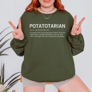 May include: A green sweatshirt with the text "POTATOTARIAN" and a definition of the word. The definition is: "Someone who firmly believes French fries are vegetables, mashed potatoes count as self-care, and tater tots are a balanced breakfast."