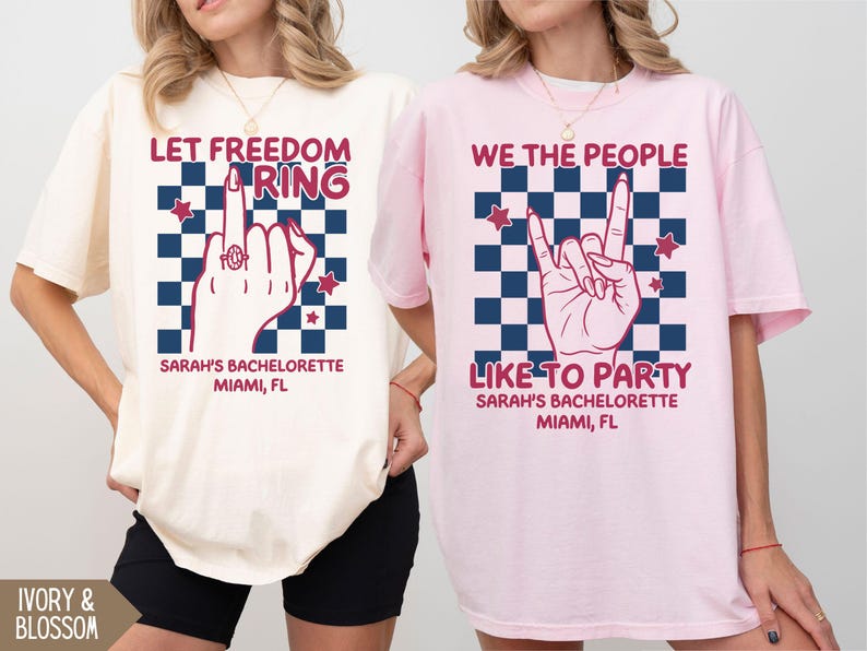May include: Ivory and pink t-shirts with graphic designs. One shirt says "Let Freedom Ring" with a hand gesture and text "Sarah's Bachelorette Miami, FL." The other says "We The People Like To Party" with a hand gesture and text "Sarah's Bachelorette Miami, FL."