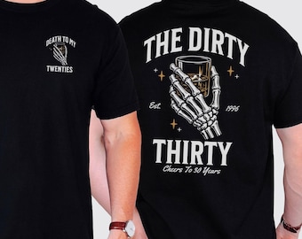 May include: A black t-shirt featuring a graphic of a skeleton hand holding a glass of whiskey. The front chest displays the text "DEATH TO MY TWENTIES." The back features the text "THE DIRTY THIRTY," "Est. 1996," and "Cheers To 30 Years."