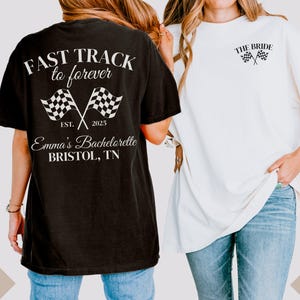 May include: Two black and white t-shirts with a checkered flag design. The black shirt says "Fast Track to Forever" with the text "Est. 2025" and "Emma's Bachelorette Bristol, TN". The white shirt says "The Bride".