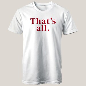 May include: White t-shirt with the phrase "That's all." printed in red. The shirt has a crew neck and short sleeves. The text is centered on the front of the shirt.