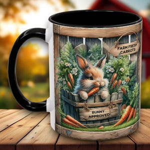 May include: White ceramic mug with a black handle and rim. The mug features a cartoon bunny rabbit eating carrots in a wooden crate with the text "Farm Fresh Carrots" and "Bunny Approved".