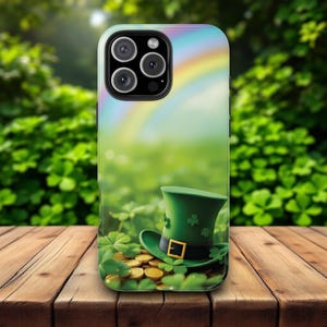 May include: A phone case featuring a St. Patrick's Day theme. The design includes a green leprechaun hat with gold coins and shamrocks, set against a backdrop of a rainbow and a field of green clovers. The case has a glossy finish.