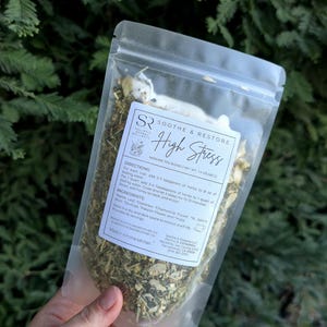 May include: A clear plastic bag of herbal tea blend labeled "Soothe & Restore High Stress." The bag contains dried herbs and flowers. The label includes directions and ingredients. The net weight is 1.4 oz.