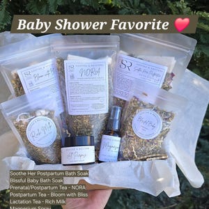 May include: A baby shower gift set featuring several clear pouches and a small jar, all labeled with the "Soothe & Restore" brand. The set includes bath soaks, teas, a magnesium spray, and an all-purpose salve. Text on the image reads "Baby Shower Favorite."