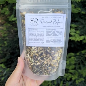 May include: A clear, resealable pouch of herbal tea blend labeled "Renewed Balance." The label includes the brand name "Soothe & Restore" and the ingredients: Dandelion Root, Nettle Leaf, Burdock Root, Spearmint Leaf, Hibiscus Flower, Ginger Root, and Orange Peel.