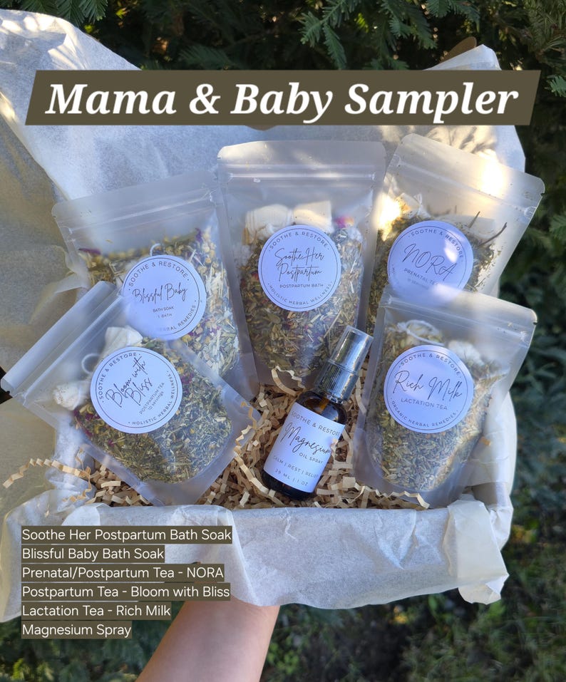 以下が含まれることがあります： 「Mama & Baby Sampler」と書かれたギフトバスケット。ハーブや紅茶が入った透明な小袋、マグネシウムオイルのスプレーボトル、製品リストが入っています。小袋には「Soothe & Restore」と書かれています。