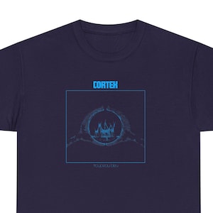 May include: A navy blue t-shirt with a graphic of a crown inside a circle formed by two hands. The text "CORTEX" and "RELAXATION" are printed on the shirt.
