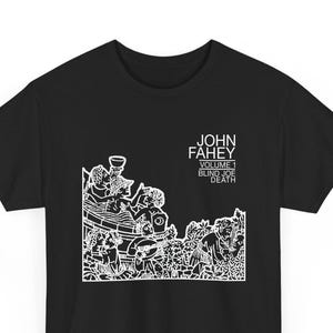 May include: Black t-shirt featuring a white graphic design and text. The graphic depicts a detailed illustration of figures and objects. The text reads "JOHN FAHEY VOLUME 1 BLIND JOE DEATH".