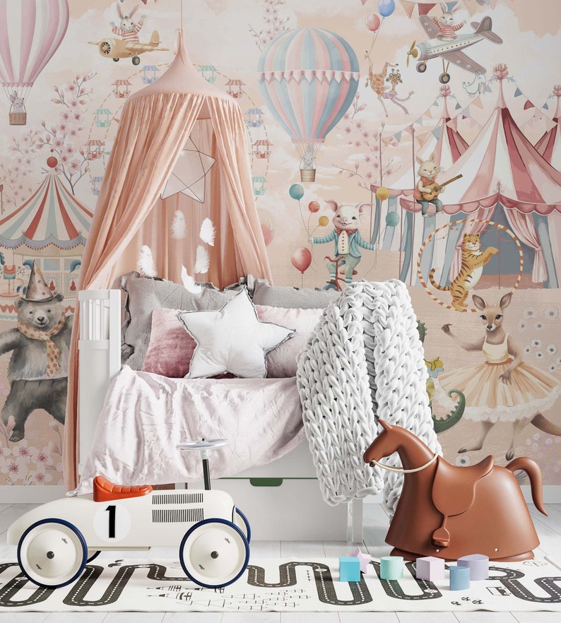 May include: A children's bedroom with a circus theme, featuring a white bed, pink canopy, and wallpaper with circus animals and hot air balloons. Includes a white toy car, a brown rocking horse, and a road-patterned rug. Soft furnishings complete the scene.