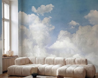 Puede incluir: Un sofá modular grande de color crema con textura se encuentra frente a una pared cubierta con un mural de un cielo azul brillante con nubes blancas y esponjosas. Una mesa de centro rectangular de piedra de color marrón claro está delante.