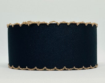 Op de afbeelding: Zwart lint met een gouden gegolfde rand.