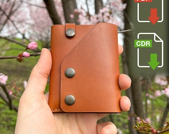 May include: A brown leather wallet with a flap closure and three silver metal snaps. The wallet is being held in a hand.
